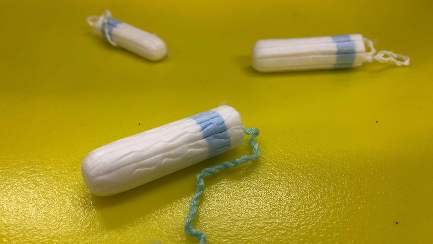 Three tampons against a yellow background