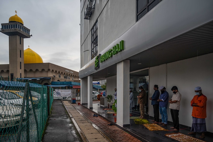 Muslims offer prayers outside a mosque due to COVID restrictions