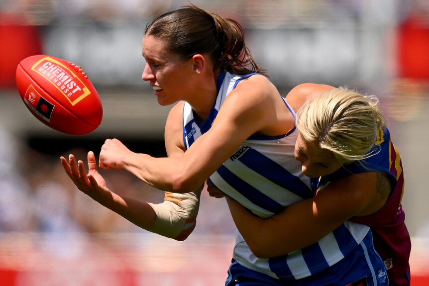 A Kangaroos AFLW layer handballs to her right against Brisbane Lions in the AFLW grand final.