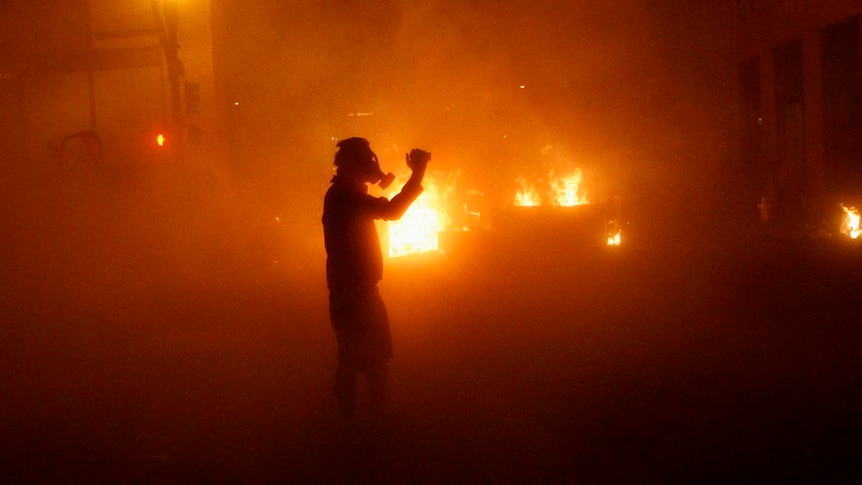 A demonstrator stands in a cloud of tear gas shot by police at the Occupy Oakland demonstration.