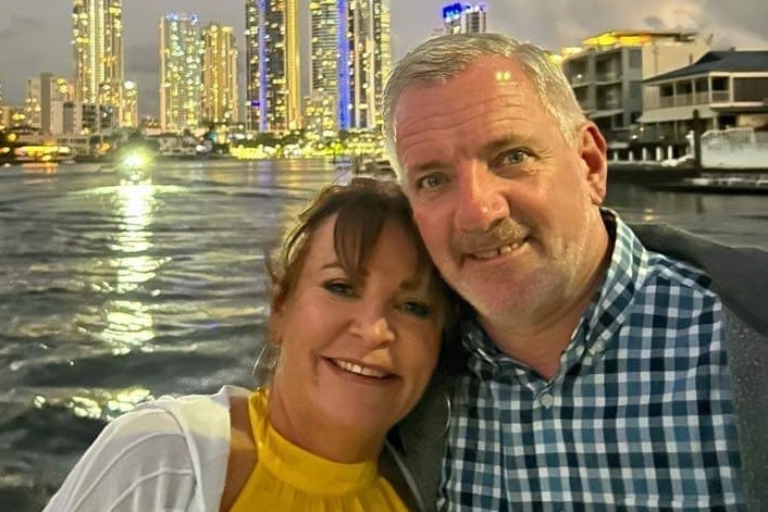Diane and Ronald (Ron) Hughes, who died in a helicopter crash on the Gold Coast, embrace with water and buildings in background