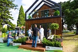 People standing outside the tiny house display home at the flower show.