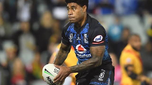 A rugby league football player holding a football during a match.