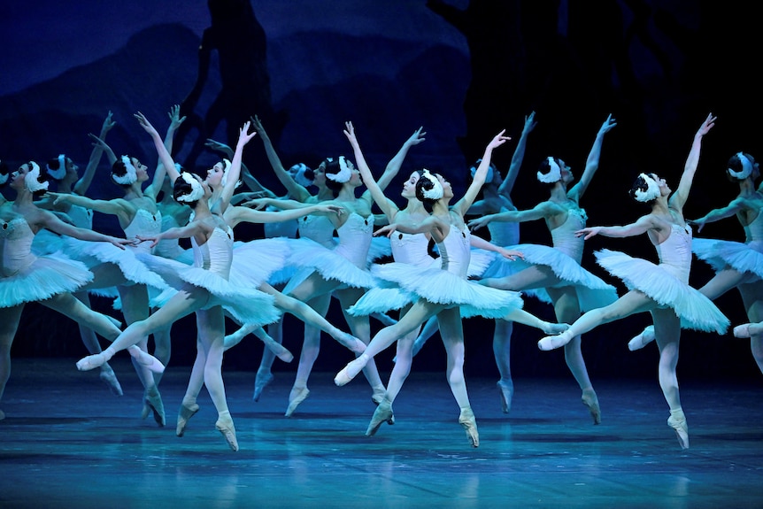 A group of ballet dances moving across the stage.