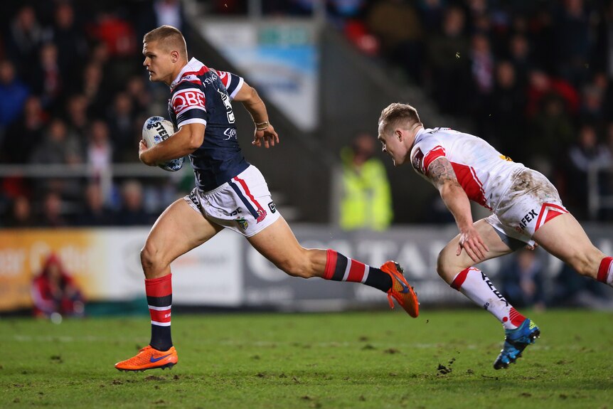 Dale Copley of the Sydney Roosters evades the tackle of St Helens' Adam Swift on his way to score a try