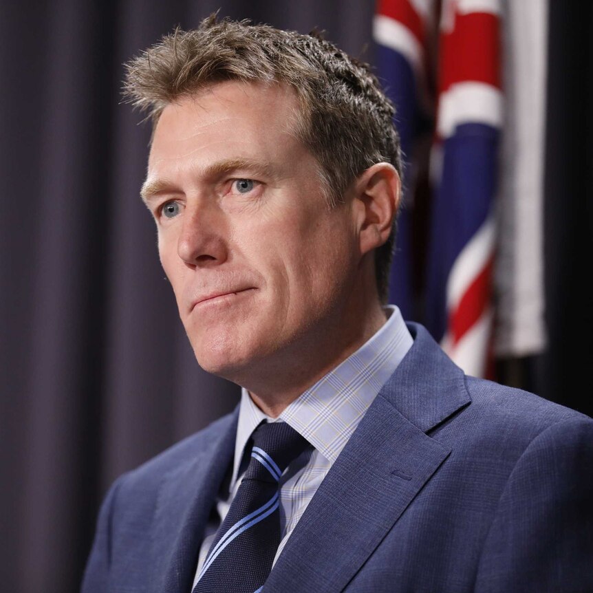 Christian Porter stands in front of an Australian flag
