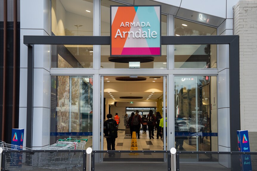 Arndale Shopping Center entrance, cars parked in front of building