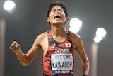 A Japanese man crosses the finish line of a marathon.
