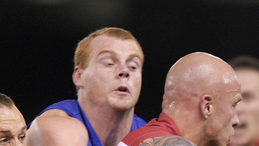 Chokehold ... Daniel Cross (l) and Adam Cooney wrap up the Demons' Nathan Jones.