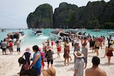 Tourists walk down the beach on Maya Bay