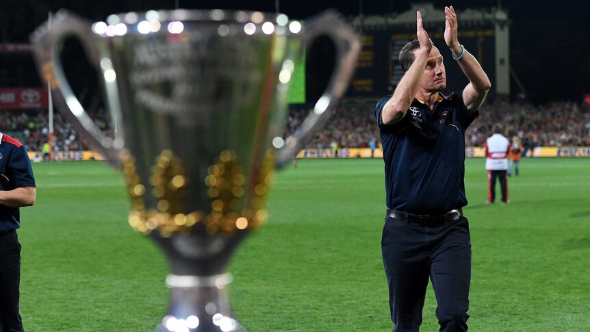 Crows coach Don Pyke walks past the premiership cup at Adelaide Oval