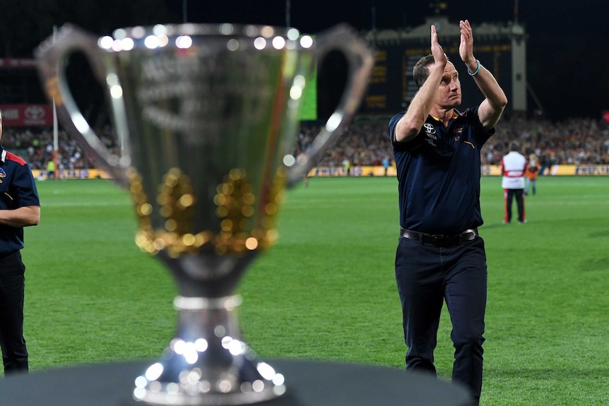 Crows coach Don Pyke walks past the premiership cup at Adelaide Oval