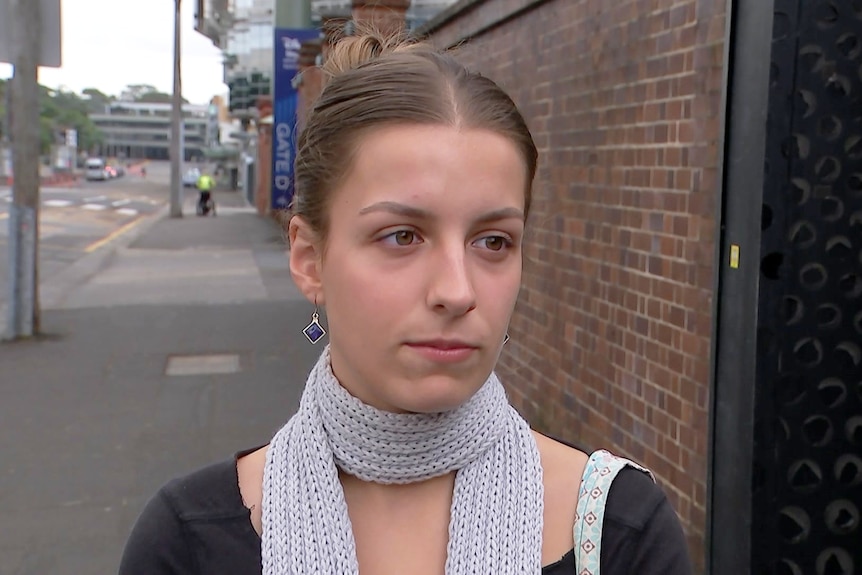 Young woman talking to media outdoors