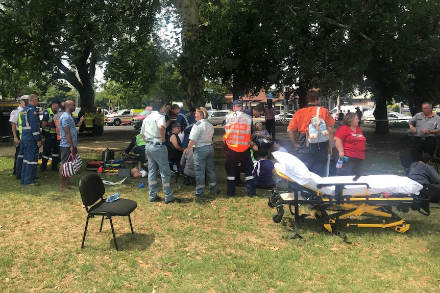 A group of people standing around in a park.