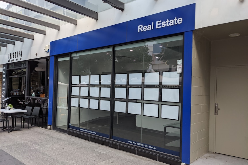 An empty real estate agent with blank photos in the window.