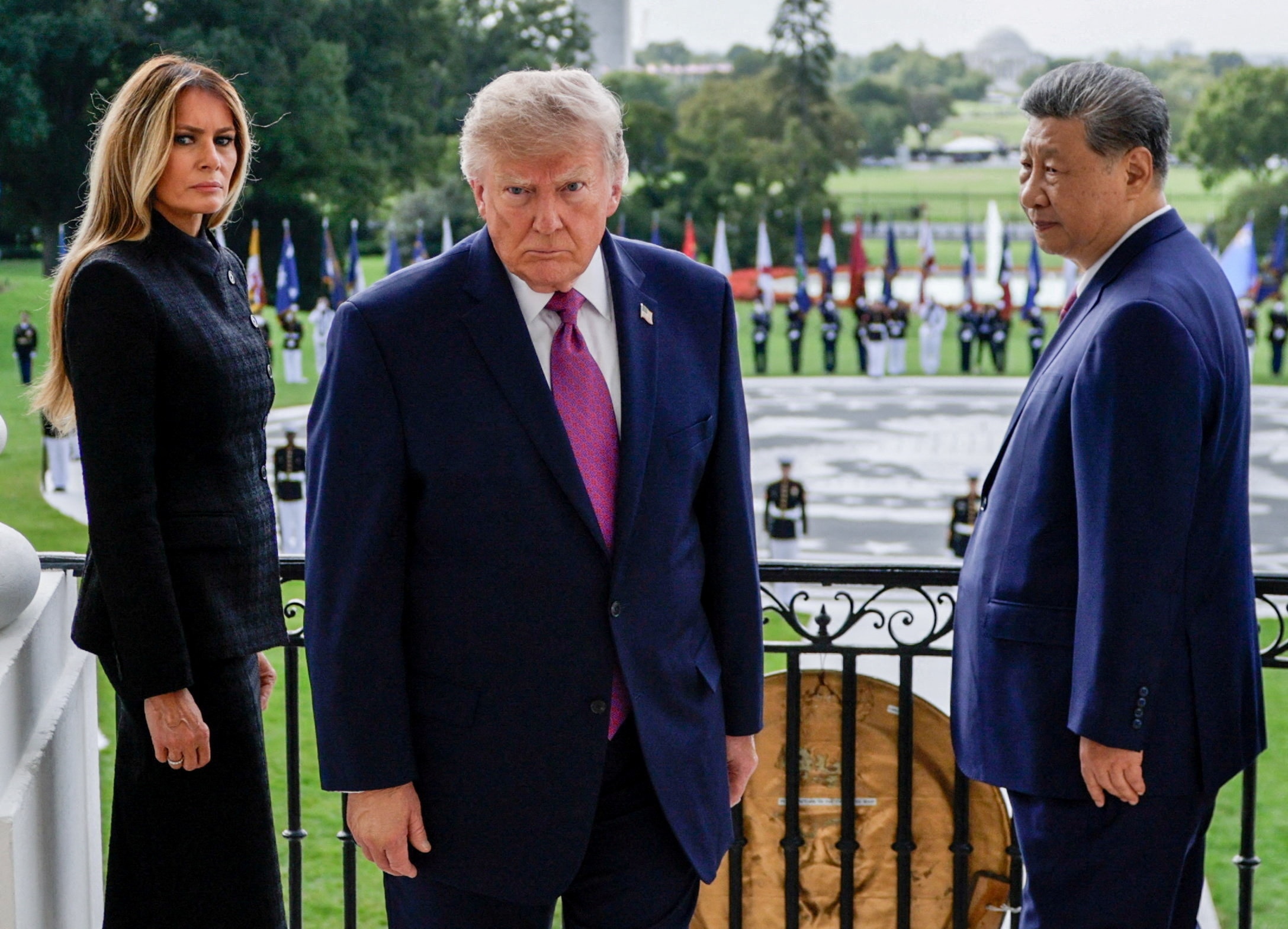 President Trump stares down the camera, while Xi Jinping looks on from his left and Trump's wife from the right.