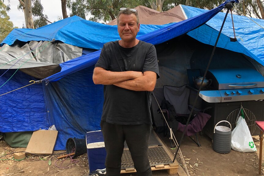 a man stands in front of his tent
