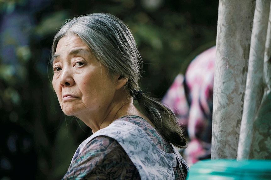 Colour close-up still of Kiki Kirin looking back in 2018 film Shoplifters.