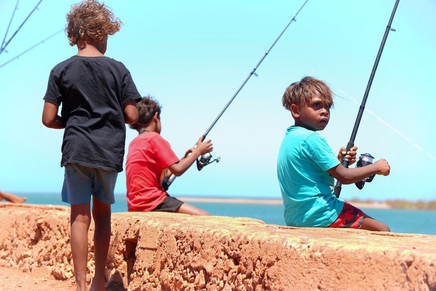 A line of kids fishing