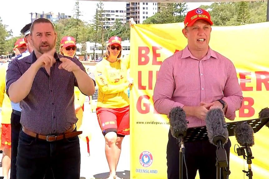 Steven Miles speaks in front of surf life savers.