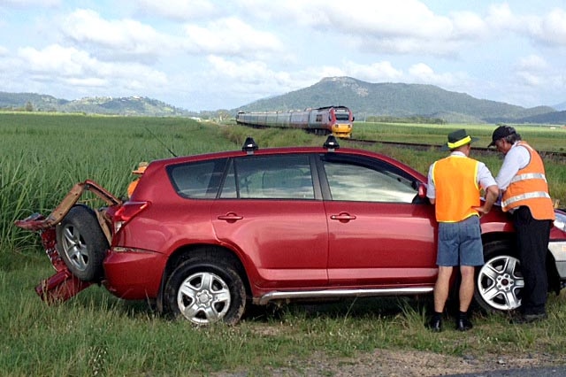 Two men stand next to a car involved in an accident with the tilt train at Farleigh.