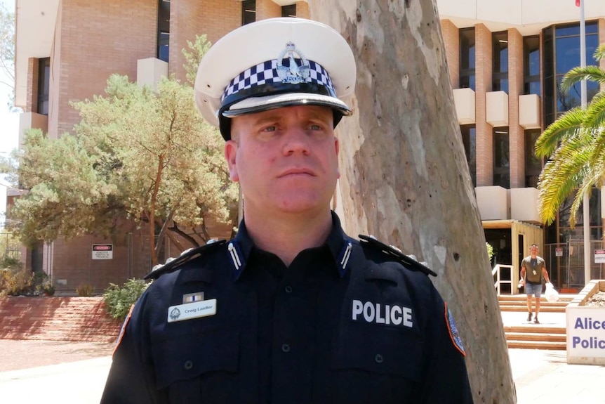Craig Laidler, wearing a police hat outside Alice Springs Police Station.