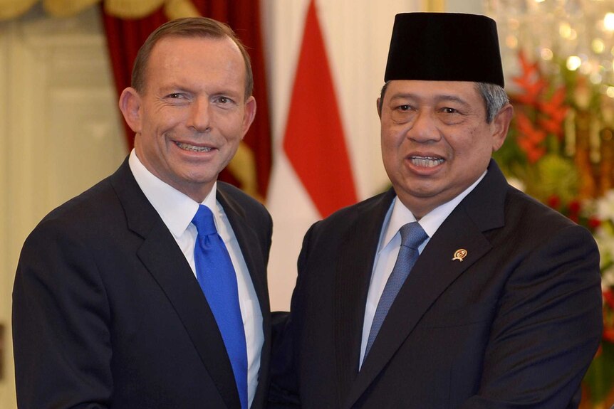 Tony Abbott shakes hands with Susilo Bambang Yudhoyono at the presidential palace in Jakarta.