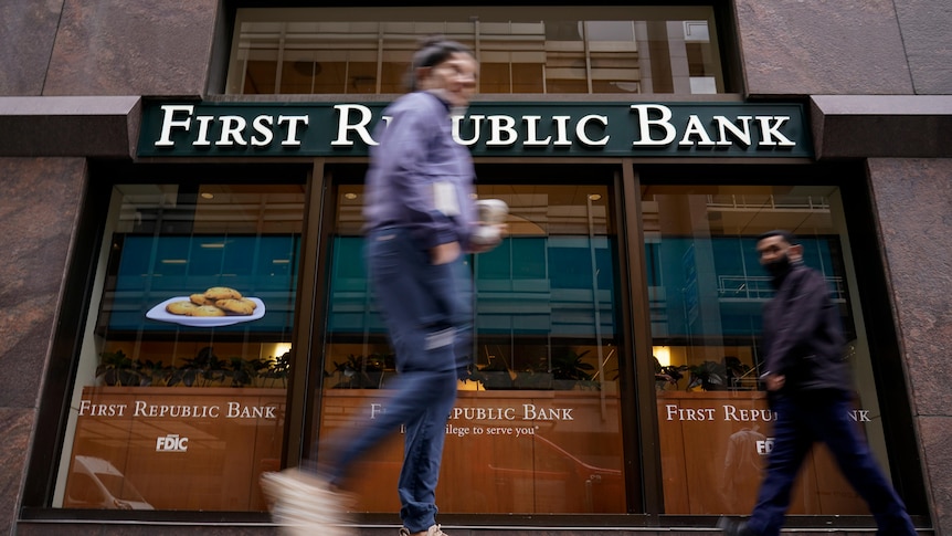 Pedestrians walk past the front door of the headquarters of First Republic Bank.