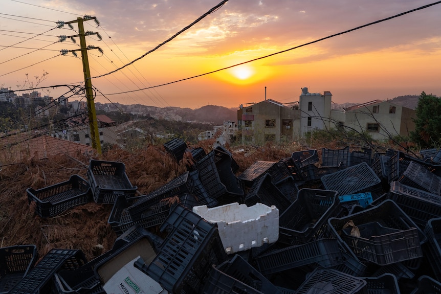 The sun setting over Beirut, with power lines in the foreground 