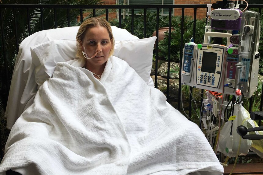 Sally Woods sits in a hospital bed.