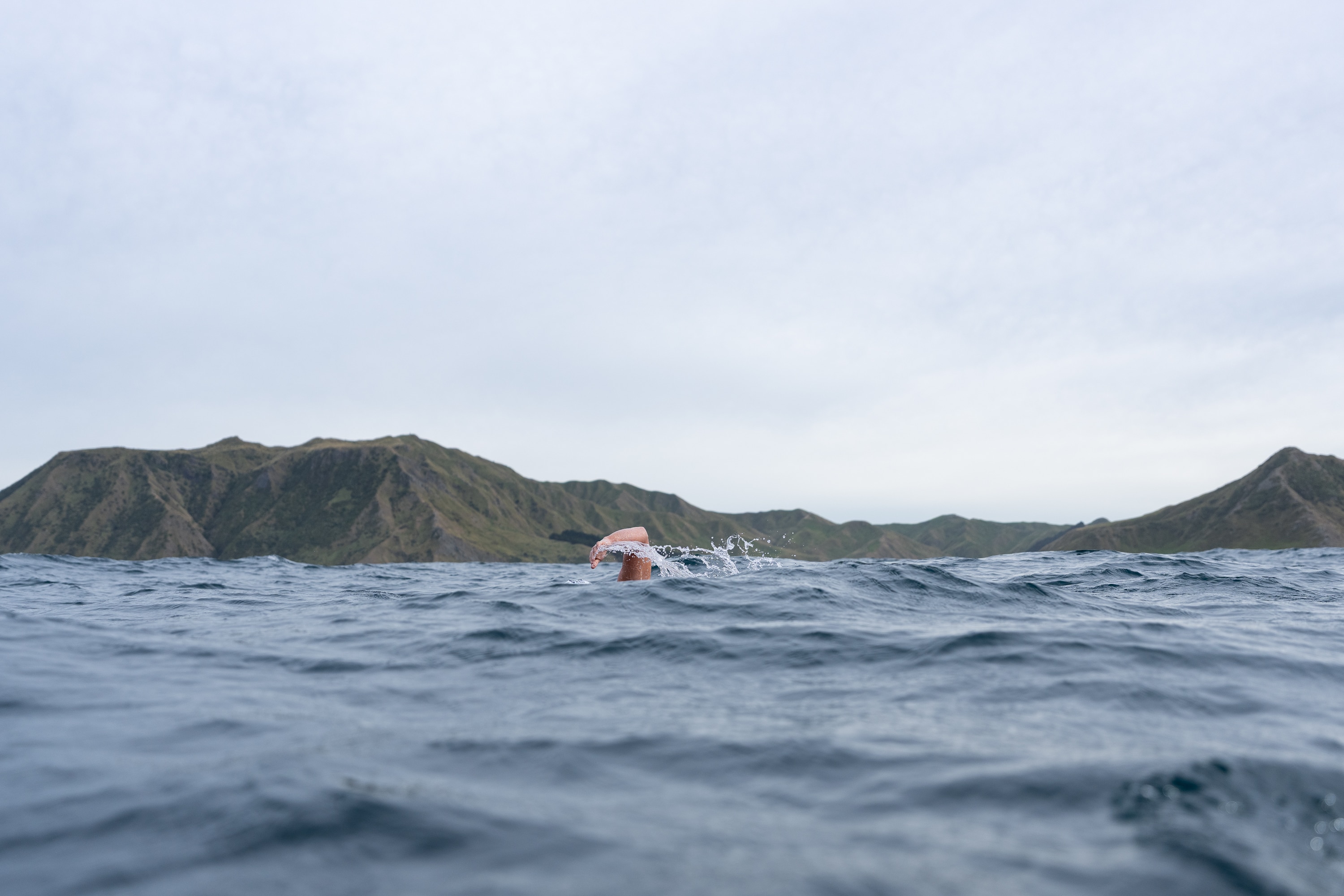 Jono Ridler swims with mountains in the background