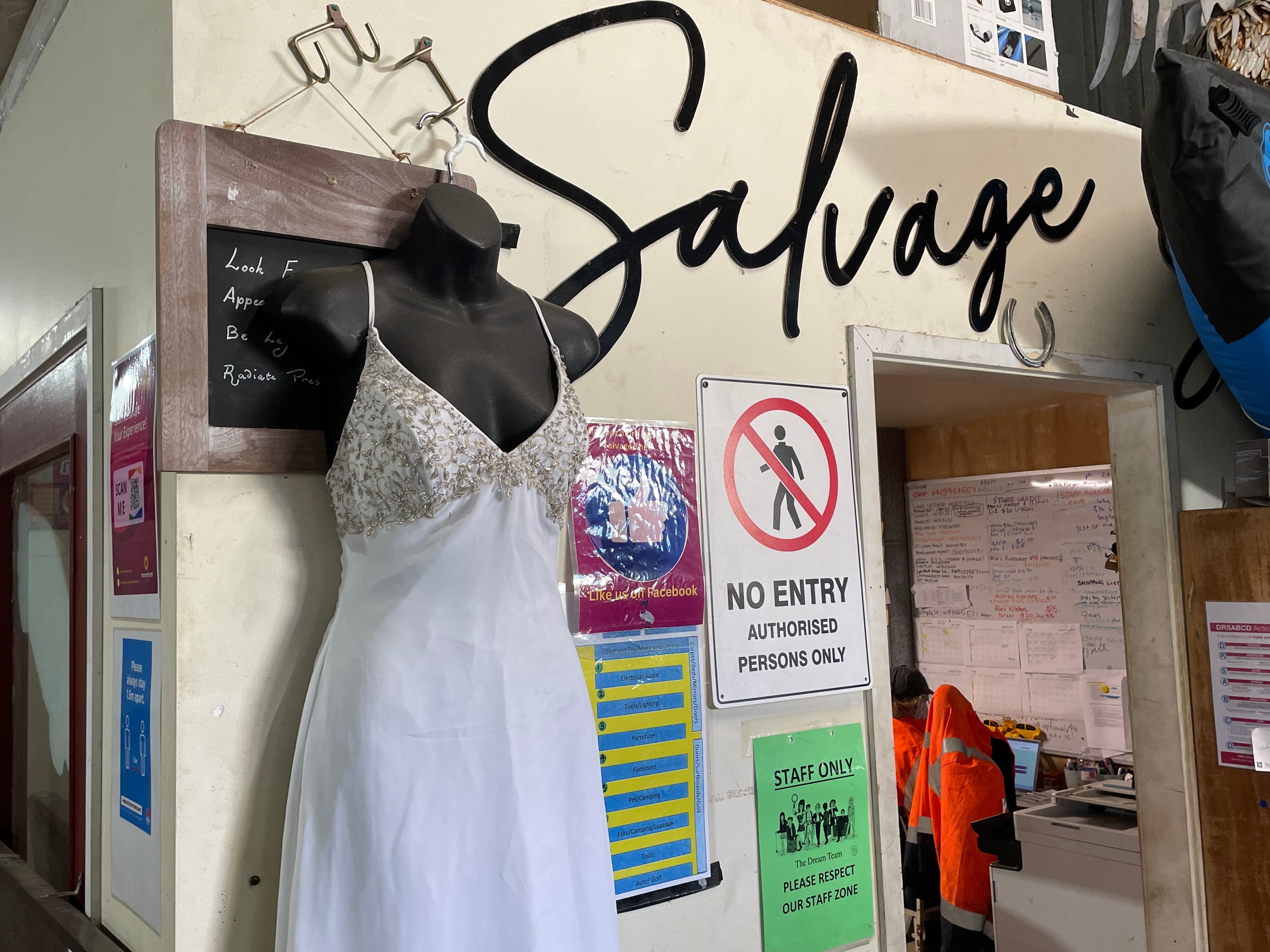 A dress on a hanging on a wall that says salvage.