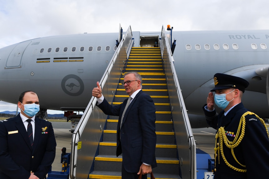 Anthony Albanese gives a thumbs up in front of an Air Force jet.