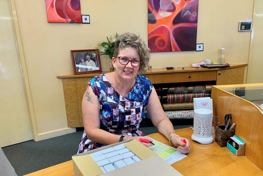 Helen Thorne sits at her desk with paperwork.