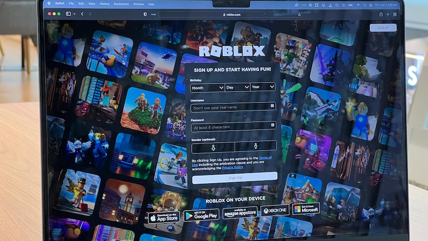A laptop is open with the login page for Roblox open. 