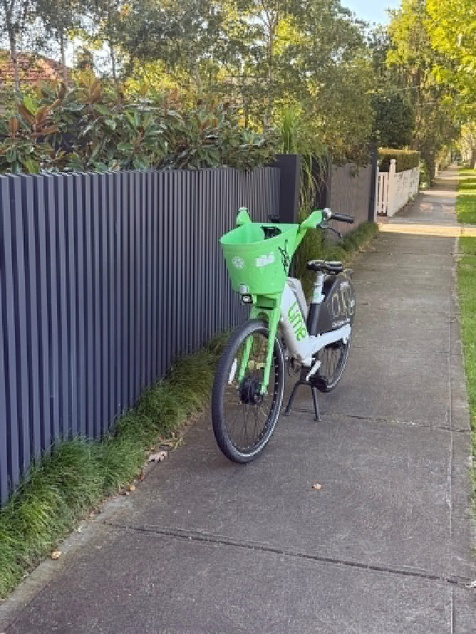 A green and white e-bike left in the middle of a footpath