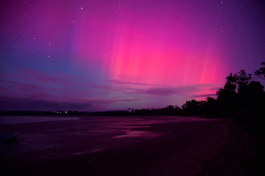 Pink lights in the sky over a beach