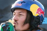 An Australian male snowboarder kisses his gold medal at the 2013 snowboard world championships.