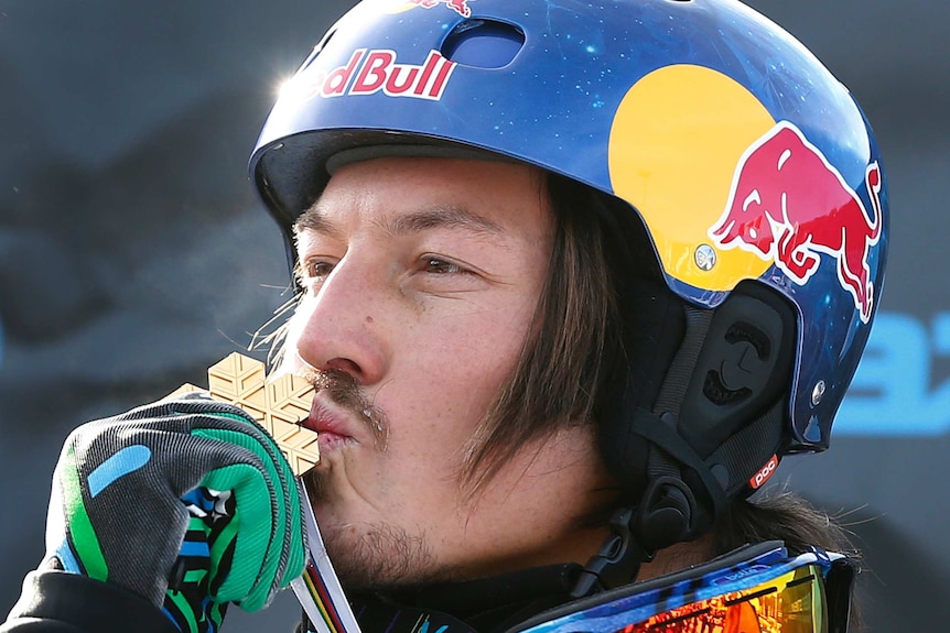 An Australian male snowboarder kisses his gold medal at the 2013 snowboard world championships.