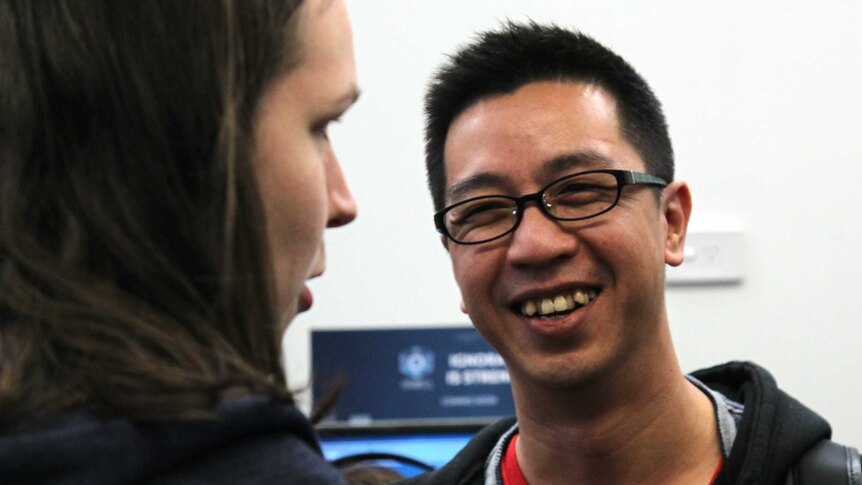 Henry Fong having a conversation with someone and laughing.