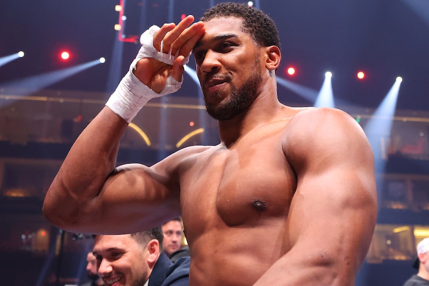 Anthony Joshua salutes with his right hand after defeating Francis Ngannou in a boxing bout.