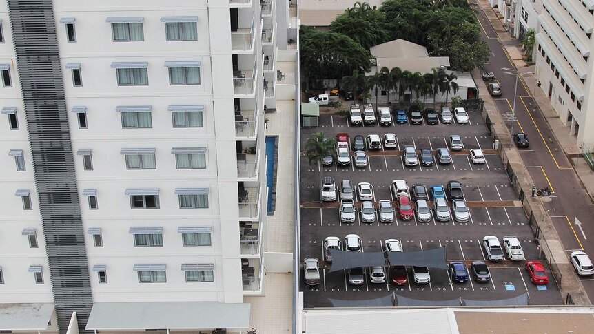 An aerial photo of Darwin city featuring a big carpark and an apartment.