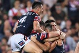 The Sydney Roosters pile on in celebration after scoring a try in the NRL grand final