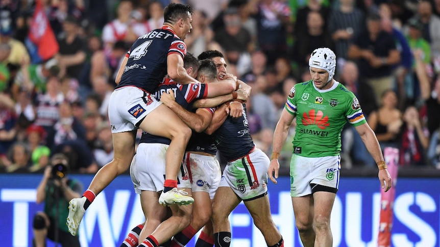 The Sydney Roosters pile on in celebration after scoring a try in the NRL grand final