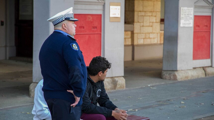 Senior Kalgoorlie police officer speaking with local youth outside the Kalgoorlie courthouse.
