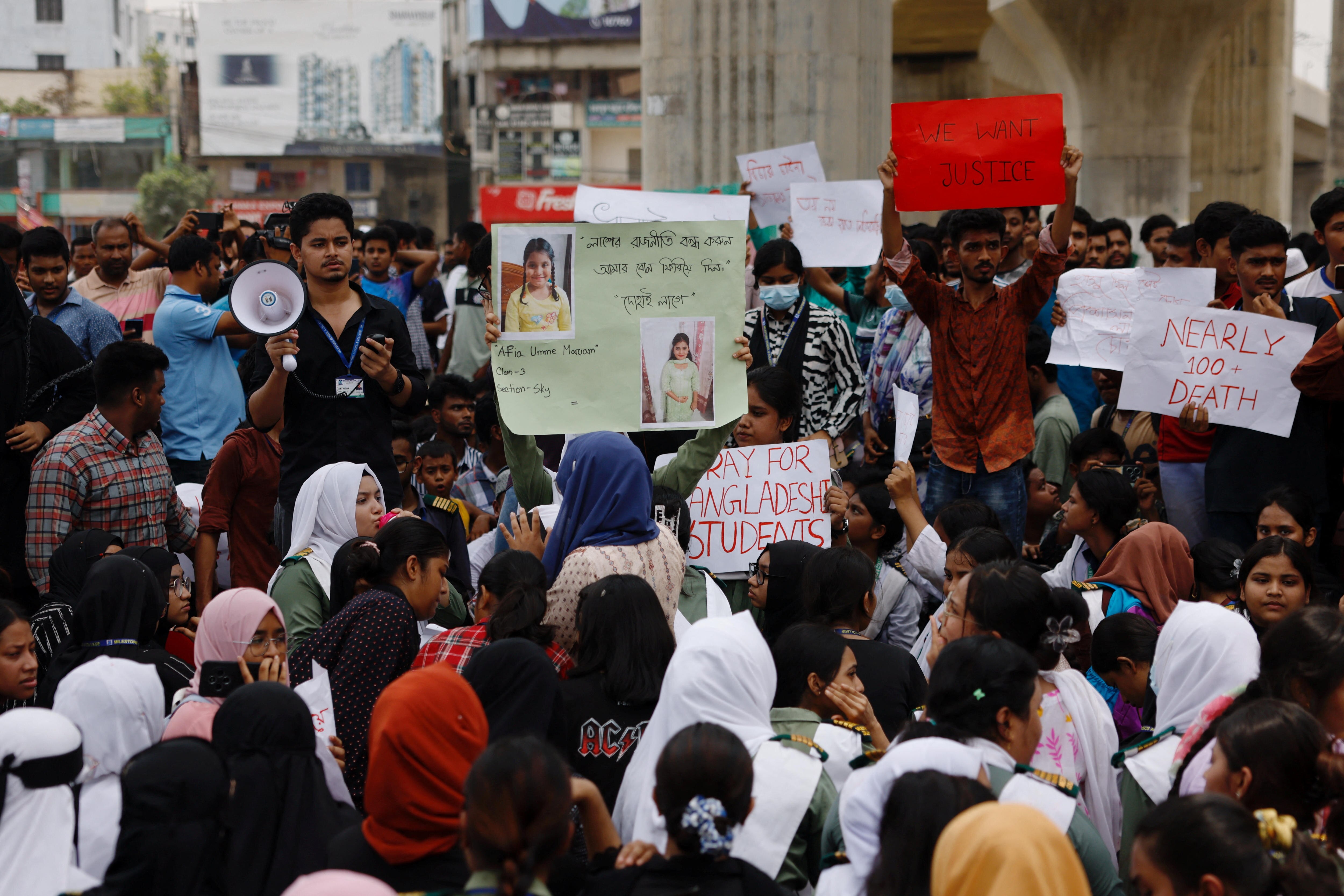 A crowd hold up banners.