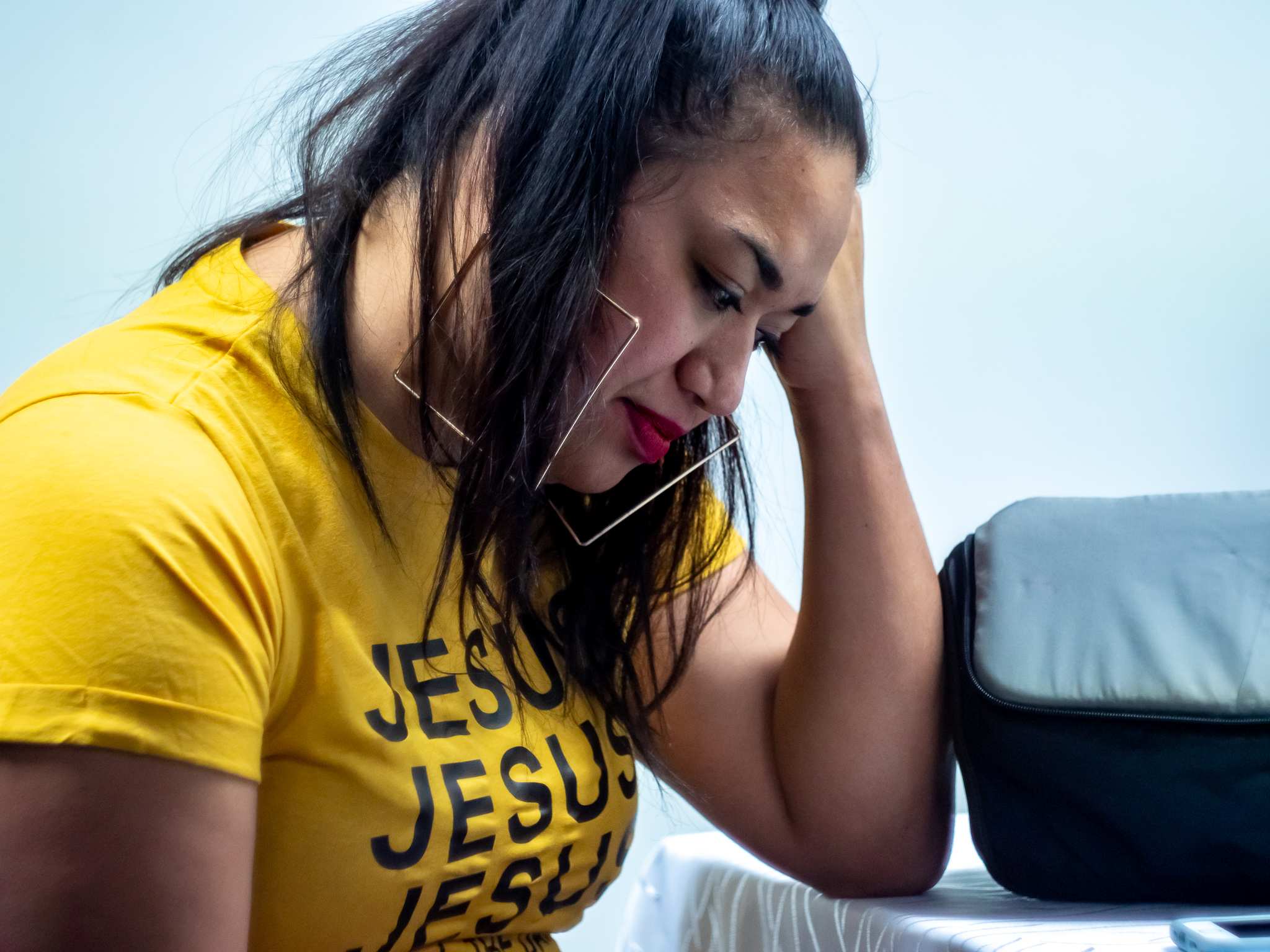 Ms Makahununiu looks pensive and thoughtful, she is wearing large gold hoop earings.