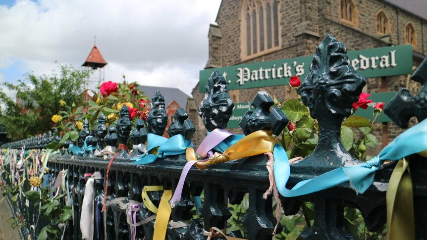 Hundreds of colourful ribbons tied to a fence outside a church