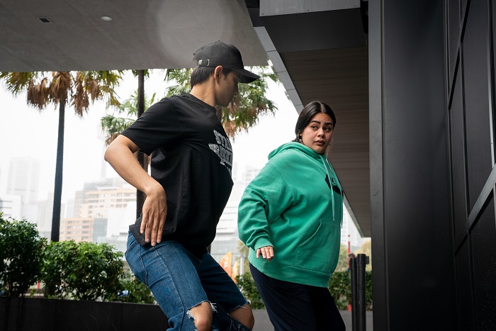 Two people practise breakdancing