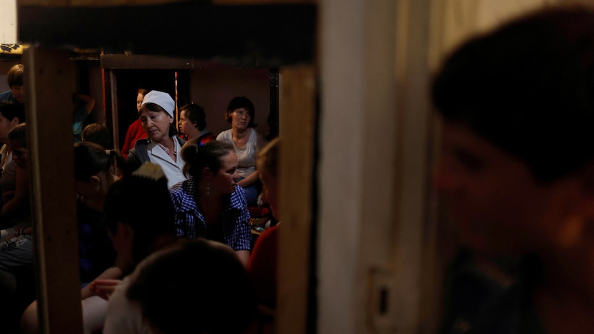 Nurse Ekaterina Masiuk, 57, comforts residents in a basement shelter at a facility for people with special needs, 